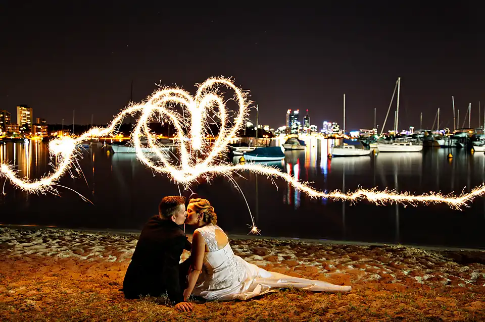 All About Image Photography - A couple kissing with sparklers by the Perth foreshore