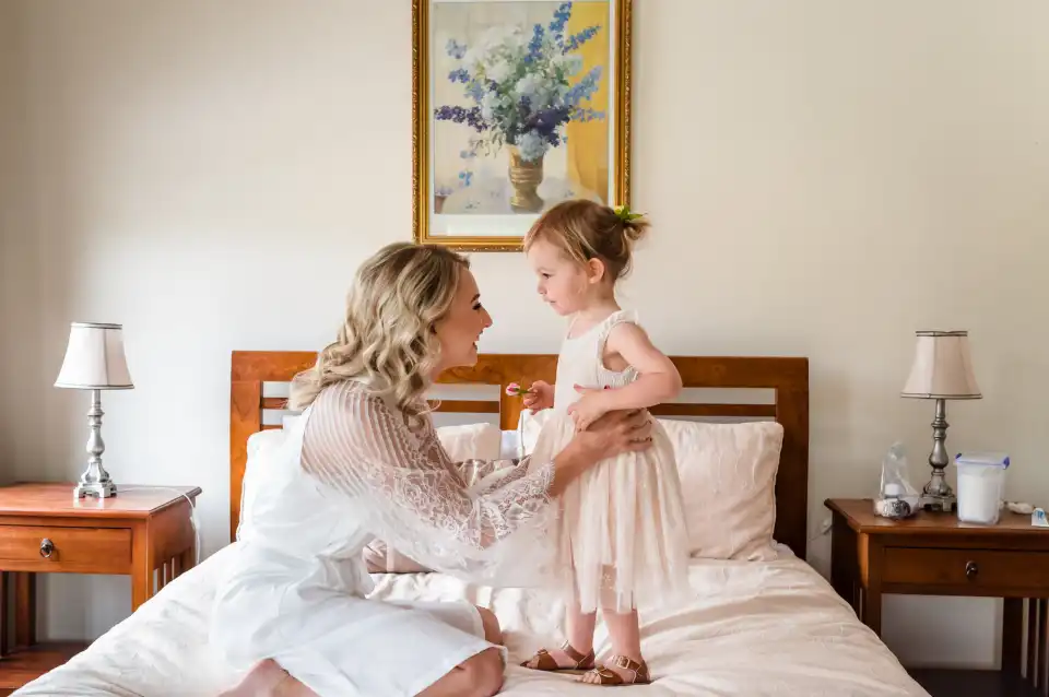Trish Woodford Photography - Bride and Flower girl on the bed