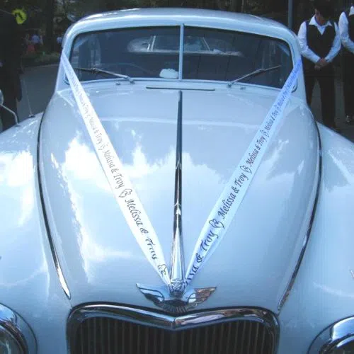 A wedding car with personalized ribbons